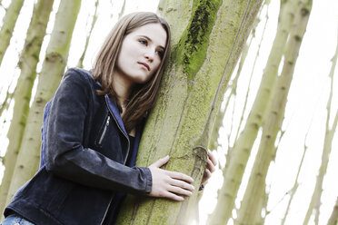 Porträt eines Teenagers zwischen Baumstämmen - JATF000677