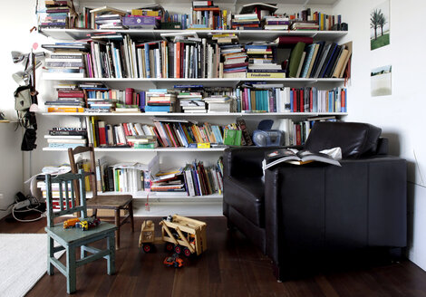 Book shelf and toys in a room with armchair and chairs - TKF000294