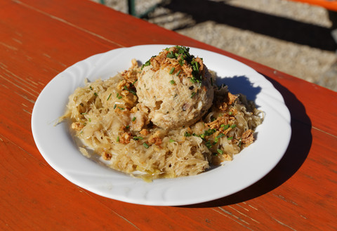 Deutschland, Oberbayern, Bayern, Chiemgauer Alpen, Speckknödel mit Sauerkraut auf Teller, lizenzfreies Stockfoto