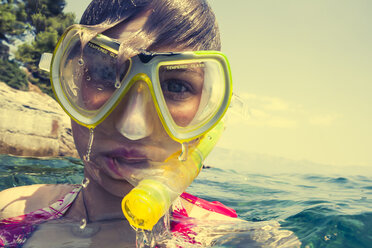 Croatia, Brac, Sumartin, Teenage girl in water with diving goggles and snorkel - DISF000603