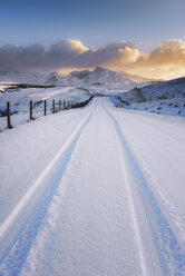 Vereinigtes Königreich, Schottland, Isle of Skye, Cuillin Hills, Straße im Winter mit Reifenspuren - SMAF000192