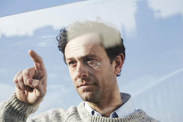 Porträt eines Mannes, der auf eine Glasscheibe zeigt - FMK000969