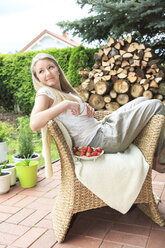 Porträt eines Teenagers auf einem Korbstuhl im Garten sitzend - VTF000118