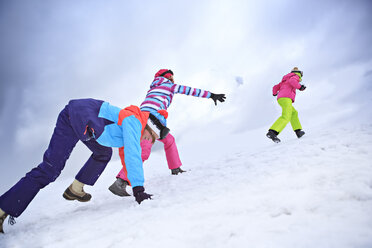 Zwei Mädchen im Teenageralter und ihre Mutter bei einer Schneeballschlacht - VTF000113