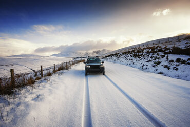 UK, Schottland, Isle of Skye, Cuillin Mountains, Allradfahrzeug auf verschneiter Straße - SMAF000197