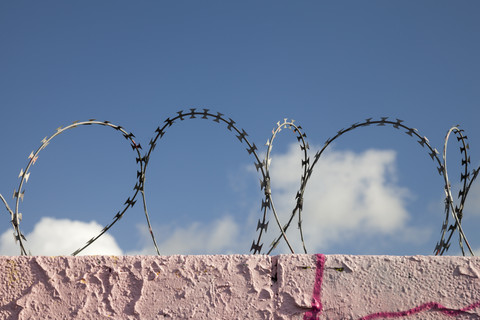 Germany, Muenster, Wall with razor barbed wire stock photo