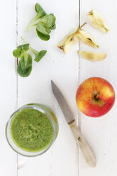 Glas mit Apfel-Lamm-Salat-Smoothie, Apfel, Küchenmesser und Feldsalat auf weißem Holztisch - EVGF000389