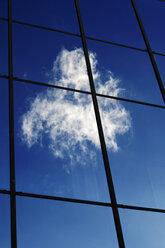 Wolken, die sich in der Glasfront eines Bürogebäudes spiegeln - HOHF000523