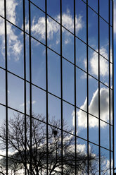 Wolken, die sich in der Glasfront eines Bürogebäudes spiegeln - HOHF000524
