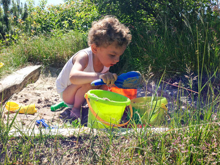Denmark, Henne beach, summer day with a child in a sandbox - AFF000001