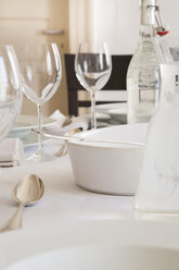 Festlich gedeckter Tisch mit Weingläsern, Silberbesteck und einer Flasche Wasser - LVF000766