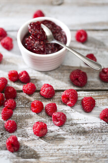 Schale mit Himbeermarmelade, Löffel und Himbeeren auf Holztisch - MAEF008001