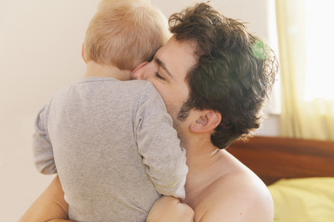 Vater kuschelt mit seinem kleinen Sohn, lizenzfreies Stockfoto