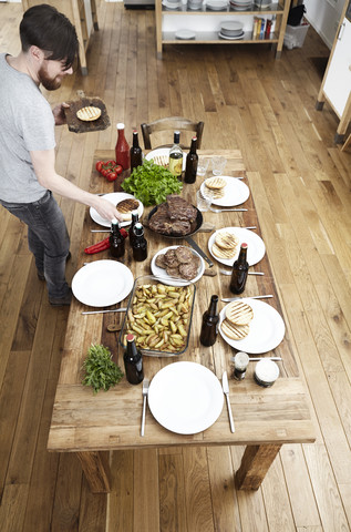 Man serving dish on wooden table stock photo