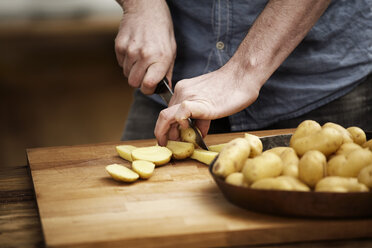 Mann schneidet Kartoffeln in der Küche - FMKF001041