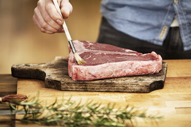 Man preparing steak in kitchen - FMKF001046