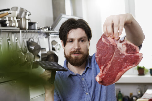 Mann in Küche mit Steak - FMKF001085