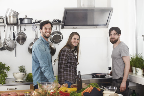 Friends preparing food in kitchen stock photo