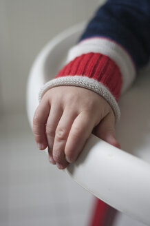 Hand eines Kleinkindes, das den Rand eines Kinderstuhls festhält - MUF001442