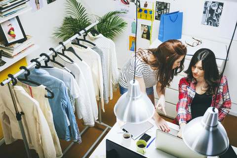 Two female fashion bloggers working in the office, elevated view stock photo