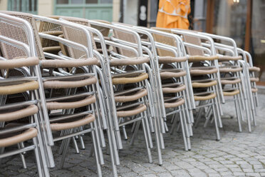 Gestapelte Stühle in einem Restaurant in der Fußgängerzone - HLF000410