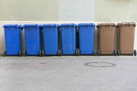 Row of blue and brown garbage cans stock photo