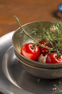 Tomaten, Gartenkresse und Knoblauch in einer Schüssel und Pfefferkörner auf einem Zinnteller - MYF000200