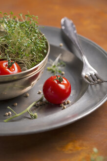 Tomate und Gartenkresse in einer Schüssel und Pfefferkörner auf dem Zinnteller - MYF000201