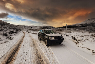 United Kingdom, Scotland, Isle of Skye, off-road vehicle at sundown in winter - SMA000199
