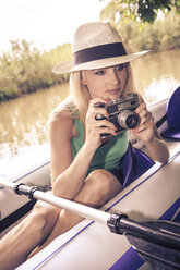 Blonde Frau mit Kamera in einem Boot - VTF000125