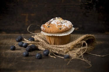 Blaubeermuffin, Jute und Blaubeeren auf Holztisch - MAEF008093