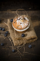 Blaubeermuffin, Jute und Blaubeeren auf Holztisch, Blick von oben - MAEF008094