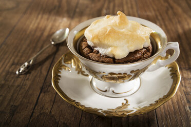 Gebackener Mokka-Mandel-Kuchen mit Baiserhaube auf Holztisch - CSTF000109