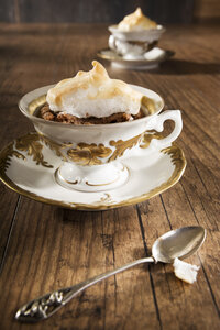 Gebackener Mokka-Mandel-Kuchen mit Baiserhaube und Teelöffel auf Holztisch - CSTF000111