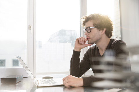 Porträt eines jungen Architekten mit Laptop in seinem Büro, lizenzfreies Stockfoto