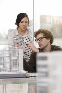 Zwei junge Architekten mit Architekturmodell im Büro - FKF000429