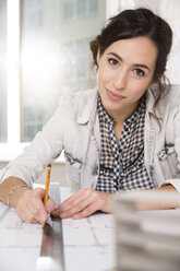 Portrait of young female architect working at her desktop in office - FKF000450