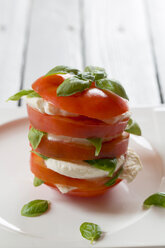 Geschnittene Tomaten, Mozzarella und Basilikum auf dem Teller - SARF000310