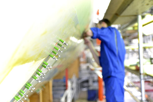 Man working on airplane in a hangar - SCH000047