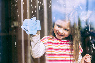 Porträt eines lächelnden kleinen Mädchens, das Fenster putzt - SARF000312