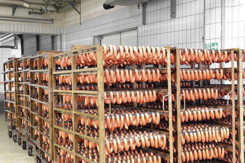 Würstchen auf Regalen in einer Fabrik, lizenzfreies Stockfoto