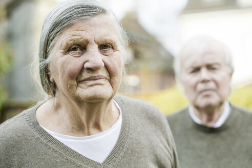 Porträt einer älteren Frau mit Ehemann im Hintergrund - JATF000714