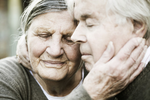 Portrait of senior couple head to head with closed eyes stock photo