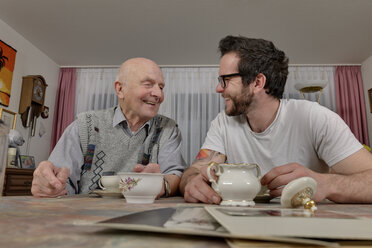 Grandfather and grandson drinking coffee at home - LAF000648