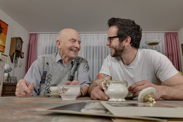 Großvater und Enkel trinken Kaffee zu Hause - LAF000648