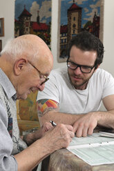 Grandson helping his grandfather by making tax declaration - LAF000654