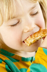 Porträt eines kleinen Mädchens, das mit geschlossenen Augen isst - JFEF000299