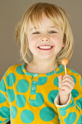 Portrait of happy little girl holding lolly - JFEF000276