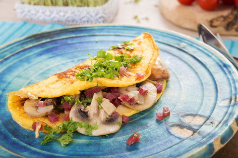 Omelette mit Champignon, Zwiebel und Schinken auf Teller, lizenzfreies Stockfoto