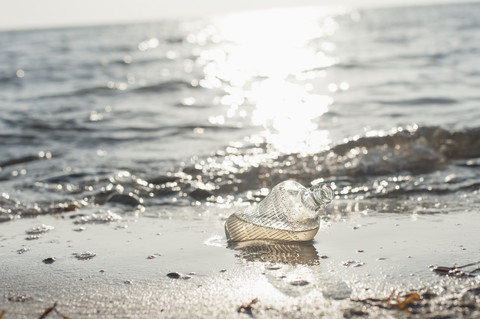 Deutschland, Mecklenburg-Vorpommern, Rügen, Glasflasche am Strand, lizenzfreies Stockfoto